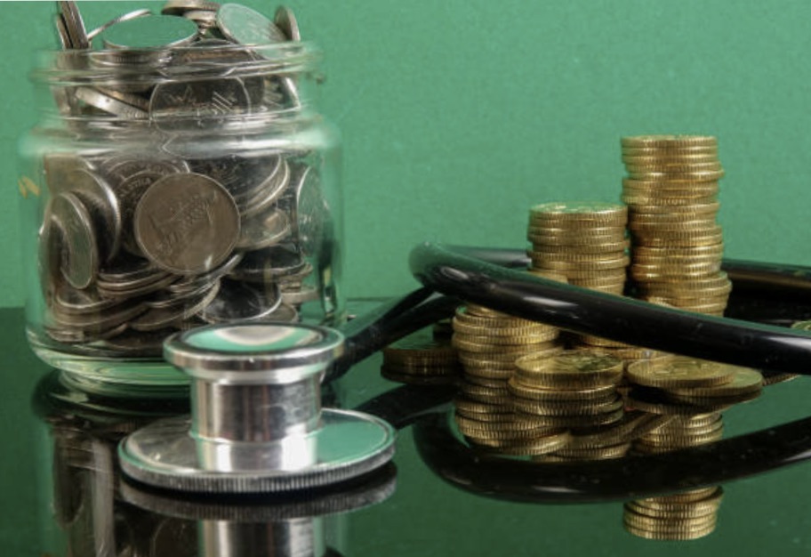 Medical cost concept with stethoscope and coins .on a green background.