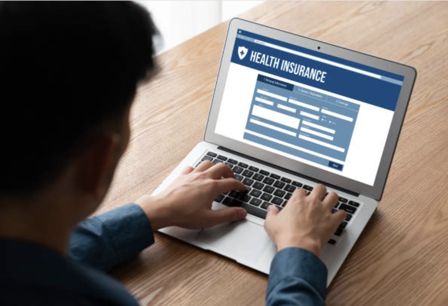 A man is filling the health insurance form on laptop.